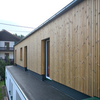 Fassade eines Holzanbaus von rechts